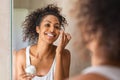 Black girl applying lotion on face Royalty Free Stock Photo