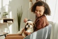 Black girl brushing pet dog enjoying time together at home lit by sunlight Royalty Free Stock Photo