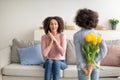 Black girl celebrating mother's day, greeting mom with tulips