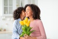 Black girl celebrating mother's day, greeting mum with flowers Royalty Free Stock Photo