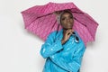 Black Girl with Pink Umbrella and Blue Raincoat and Glasses deep in thought Royalty Free Stock Photo
