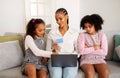 Black Girl Envying Shopping Online With Mother And Sister Indoor