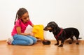 Black girl feed her dog pet with food