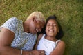 Black girl and grandmother lying on grass, overhead close up Royalty Free Stock Photo