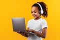 Black girl in headset standing with laptop at studio Royalty Free Stock Photo