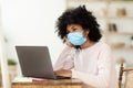 Black Girl In Medical Mask Sitting At Laptop At Home Royalty Free Stock Photo