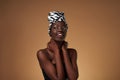 Black girl wearing african turban looking away