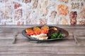 Black glass plate with lunch, beef on with potatoes and grilled vegetables