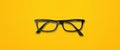 Black glasses isolated on yellow banner Royalty Free Stock Photo