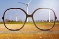 Black glasses with wind wheels in the background