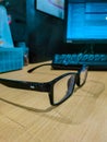 a black glasses on a wooden table at the office