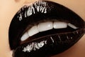 Black glossy lips makeup. Macro beauty shot of face part. Halloween look with black lipstick