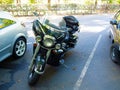 Black glossy motorcycle parked on the roadside between cars on a spring day Royalty Free Stock Photo