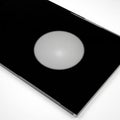A black, glossy rectangular surface features a central illuminated white sphere. The Royalty Free Stock Photo