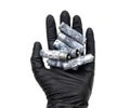 Black gloved hand holding a bunch of corroded batteries Royalty Free Stock Photo