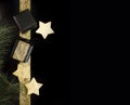 Black and gold christmas gifts with foil stars on dark background