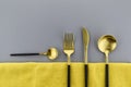 Black and gold cutlery on two tone grey and yellow