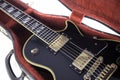 Black and gold electric guitar in red fur-lined case