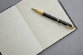 Black and gold fountain pen placed on calendar notebook. Royalty Free Stock Photo