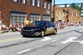 A black and gold sheriff car driving through the fourth of July parade