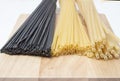 Black and golden spaghetti, pastes on a wooden board