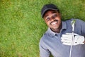 Black golfers put on white gloves and putting the golf clubs on chest while lying on the green grass Royalty Free Stock Photo