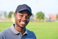 Black golfer wearing sport hat standing in an outdoor golf course