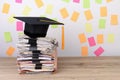 Black graduated cap and yellow tassel on stack documents,Colorful paper post it the background Royalty Free Stock Photo