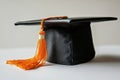 Black graduation cap with an orange tassel representing successful completion of studies Royalty Free Stock Photo