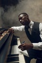 Black grand piano musician poses on the stage