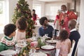 Black grandfather opening champagne for his multi generation family, gathered in the dining room for Christmas dinner Royalty Free Stock Photo