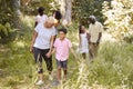 Black grandma walking with grandson and family, full length