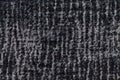 Black and gray fluffy background of soft, fleecy cloth. Texture of plush furry textile, closeup.