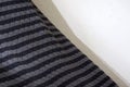 Black and gray quilted blanket against wall