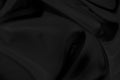 Black gray satin dark fabric texture luxurious shiny that is abstract silk cloth background . Royalty Free Stock Photo
