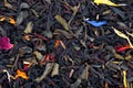 Black and green Ceylon tea with dry flowers - calendula, rose and cornflower petals, background.
