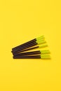Black green makeup brushes, eyelash combs and eyebrows on trendy bright yellow background with copy space, banner, flyer coupon