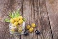 Black and green olives mixed in the bowl on wooden table, organic food, healthy nutrition Royalty Free Stock Photo