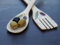 Olives with vintage spoon and fork on dark table