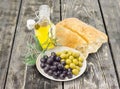 Black and green olives, olive branch, ciabatta and olive oil Royalty Free Stock Photo