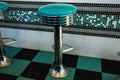 Black and green: tyipical american diner vintage interiors with stools and checkered floor Royalty Free Stock Photo