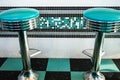 Black and green: tyipical american diner vintage interiors with stools and checkered floor