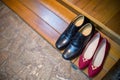 black groom Shoes and red bride shoes place on the floor. wedding high heels on brown carpet . Royalty Free Stock Photo