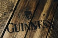 Black Guinness beer logo on rustic weathered wood