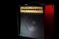 Black guitar amplifier on a black background with a red flash. Royalty Free Stock Photo