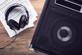 Black guitar amplifier with headphones and sheet music on wooden table Royalty Free Stock Photo