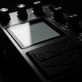 Black guitar effects pedal with multiple knobs and a digital screen. The knobs are Royalty Free Stock Photo