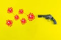 A black gun and a drawn COVID-19 virus. The coronavirus epidemic kills people and causes death. COVID-19 infection concept
