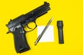 Black gun, reminder note paper, pen and flashlight lies on a yellow background. Private detectives work. Searching information Royalty Free Stock Photo
