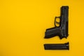 Black gun on a yellow background Royalty Free Stock Photo